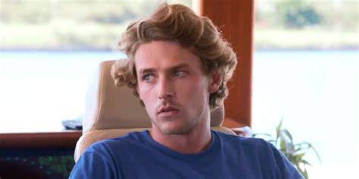 Shane Coopersmith looks concerned, sititng in blue t shirt